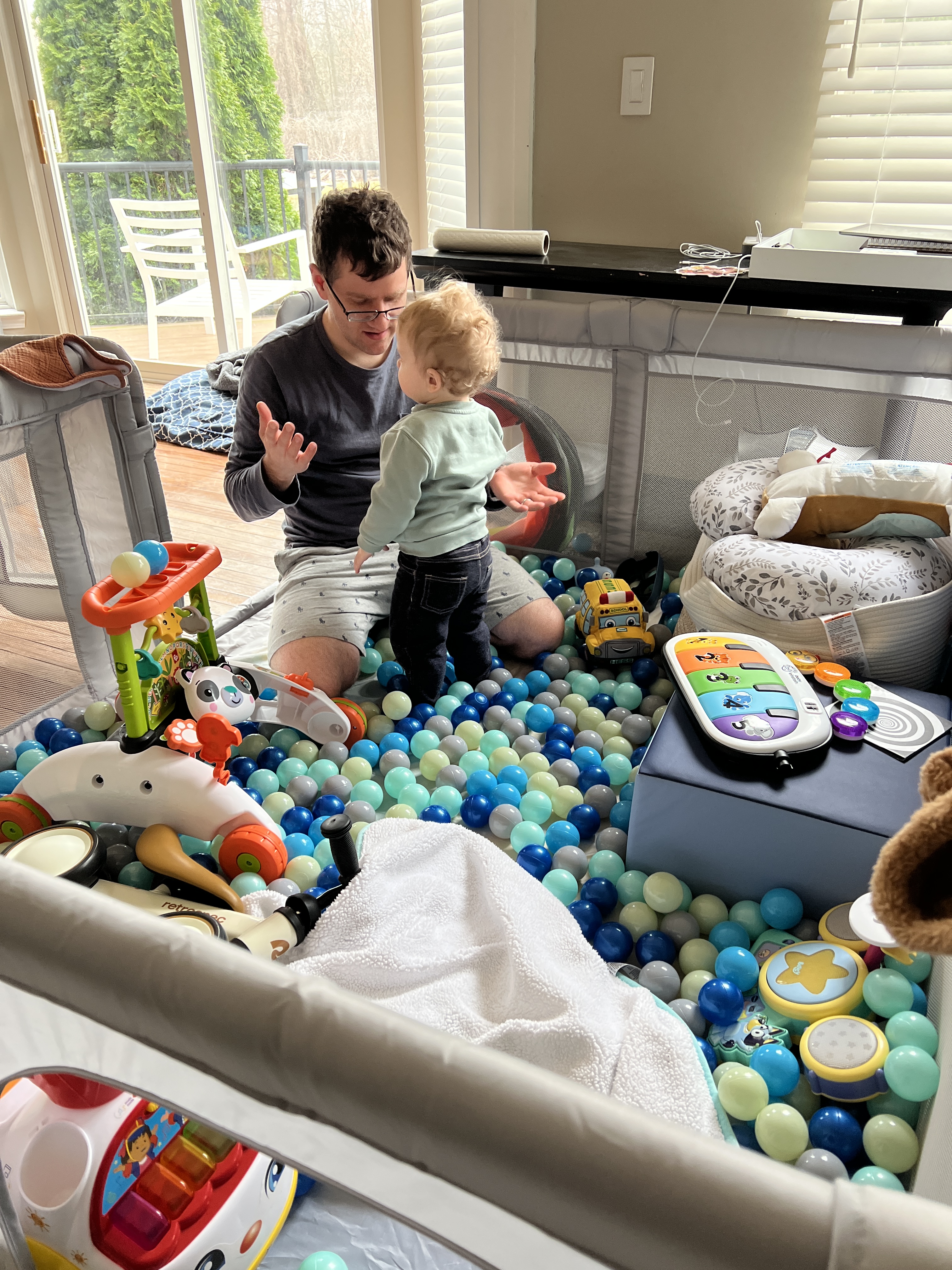 my husband and baby standing among toys